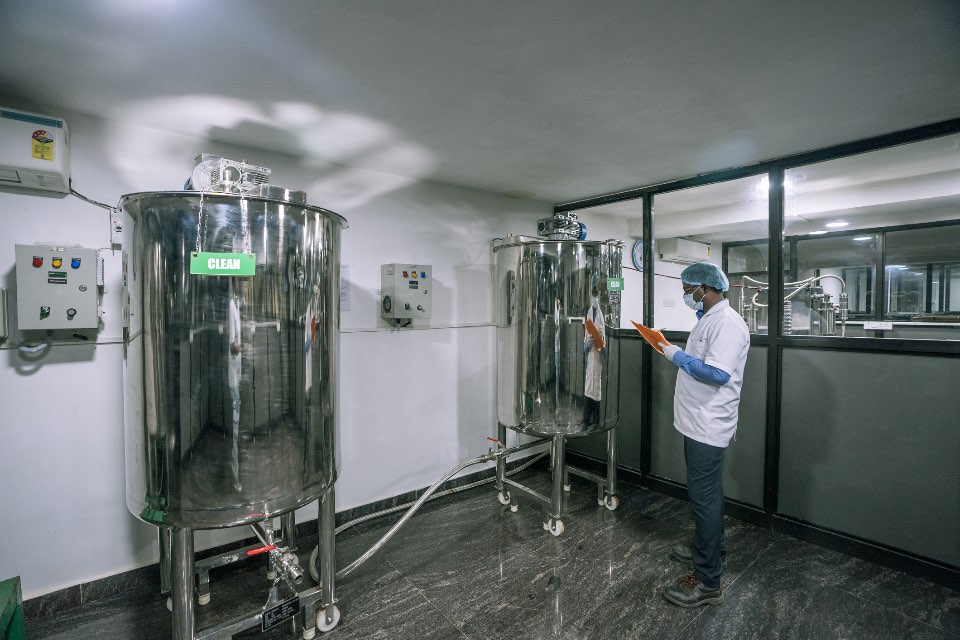 QC and pilot-scale reactors at Kelvin Bio Organics, with a technician recording batch checks